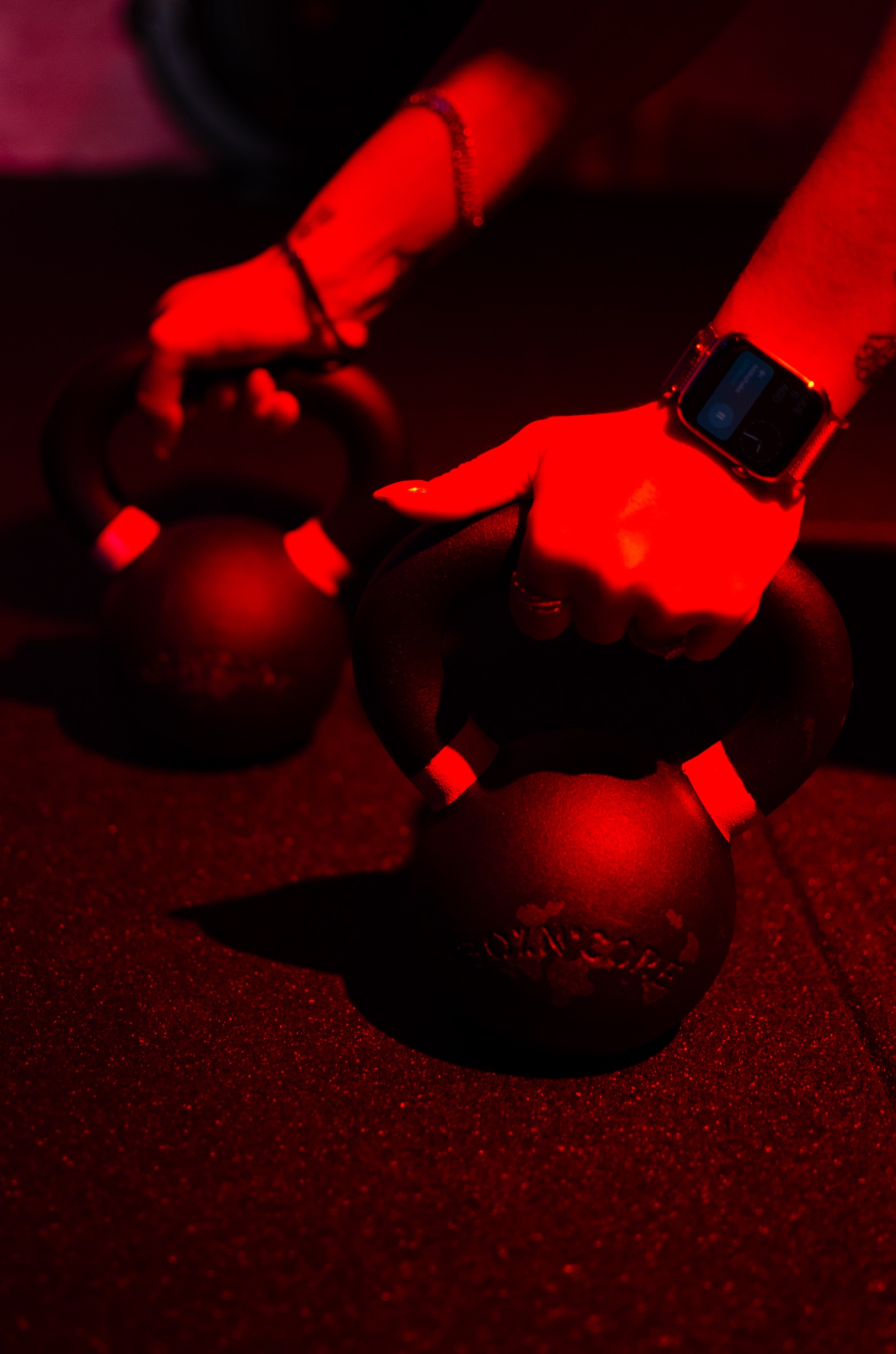 Détails mains et kettlebell en lumière rouge