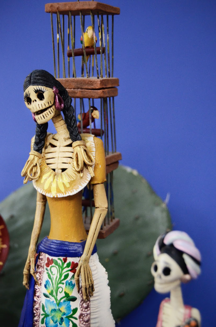 Catrina mexicaine avec cage à oiseaux sur fond bleu